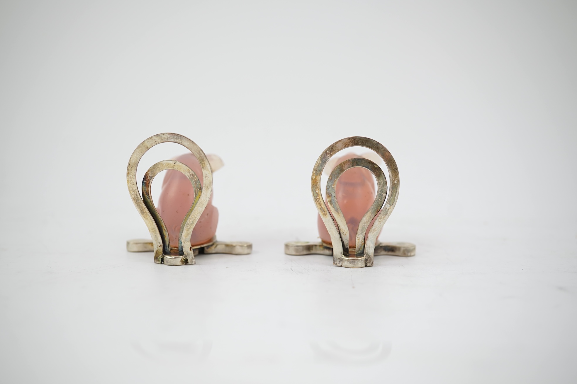 A cased pair of unusual Edwardian silver and pink glass mounted menu holders, by William Comyns, each modelled as a seated pig with collar